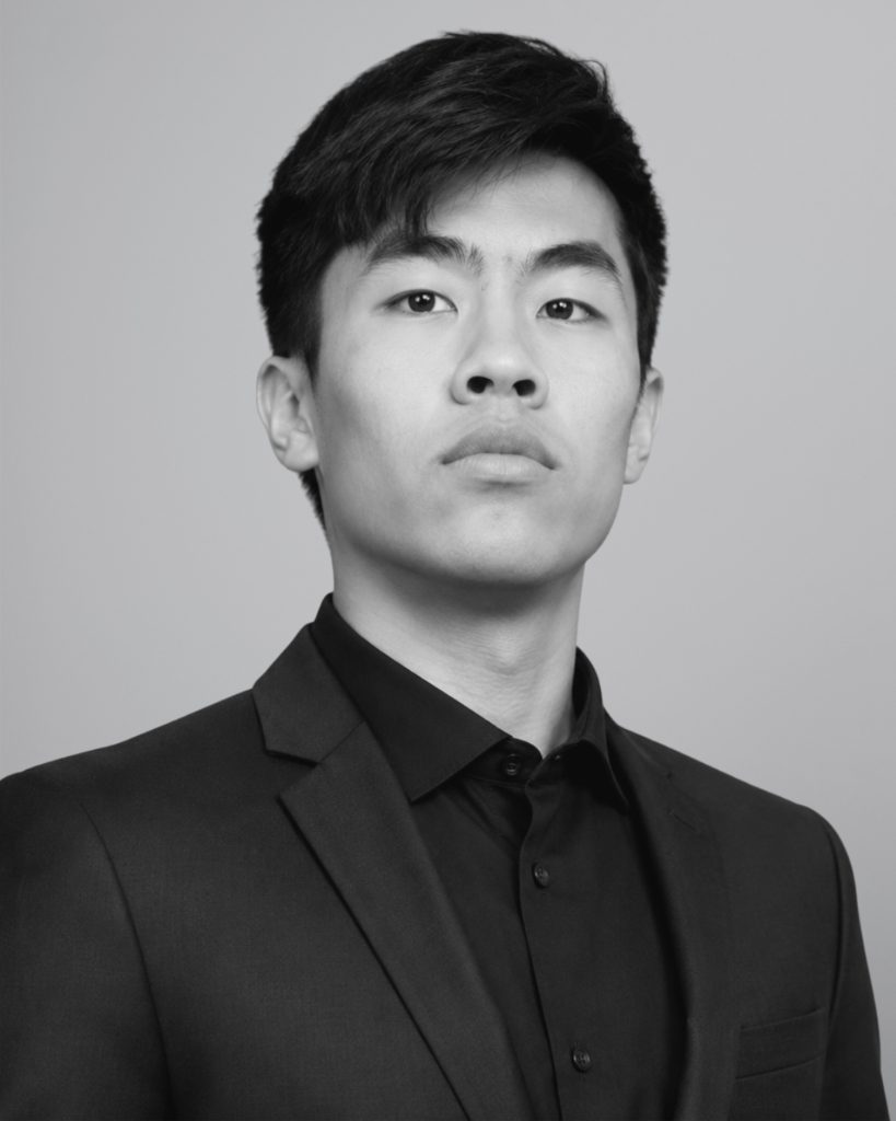 Evan Kwan, founder of Kwan Growth Labs, in a black-and-white studio portrait wearing a dark suit